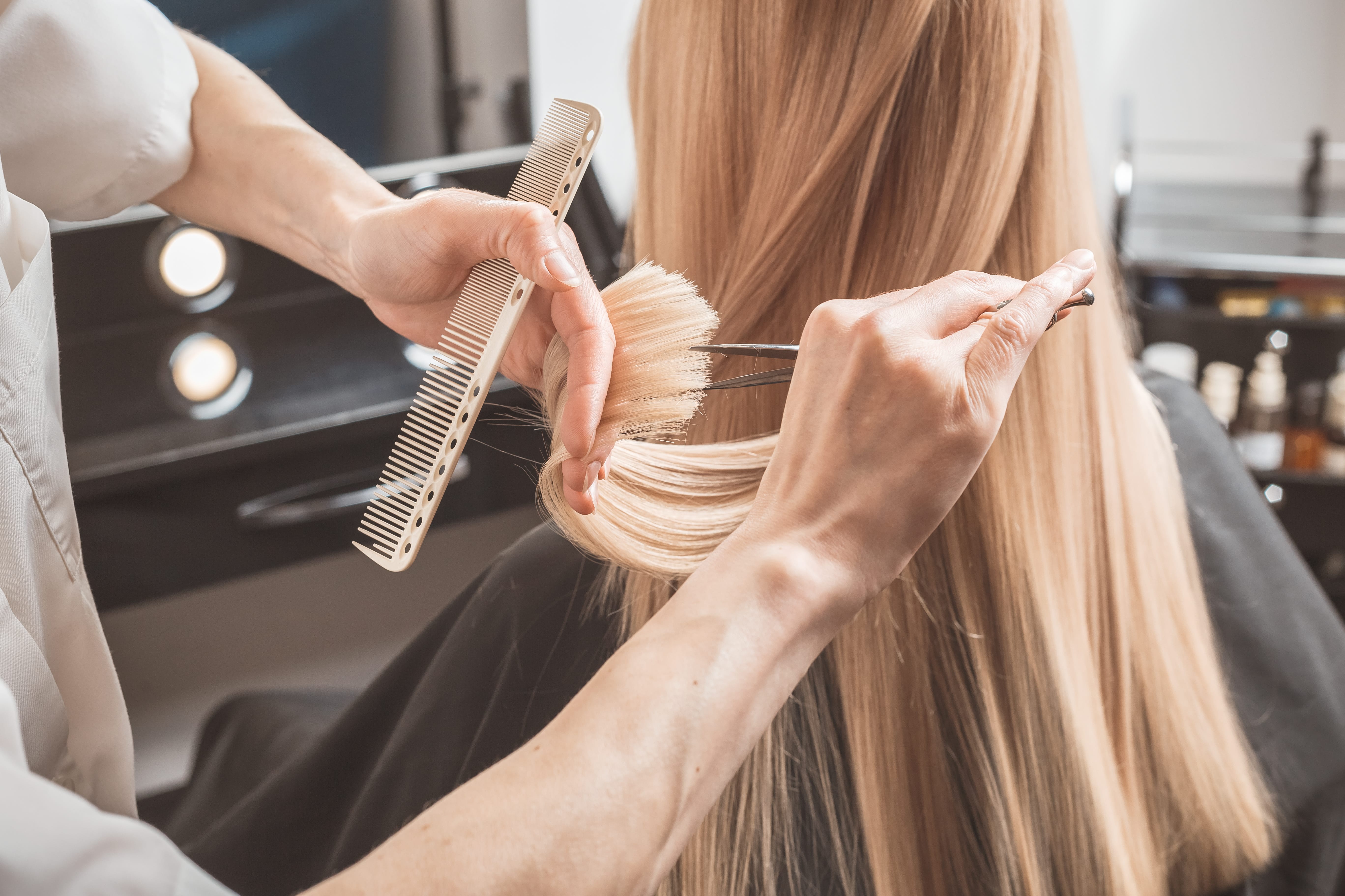 Foto von einer blonden Frau, der die Haare geschnitten werden